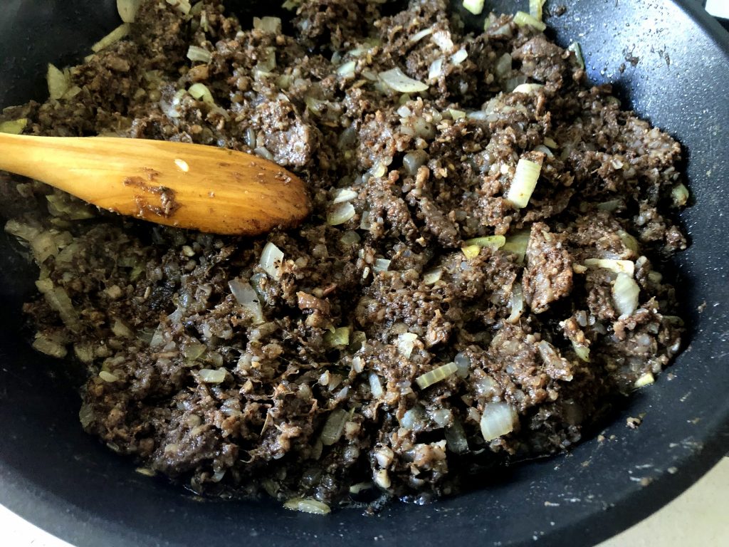 Polish kaszanka being fried on the pan with onion