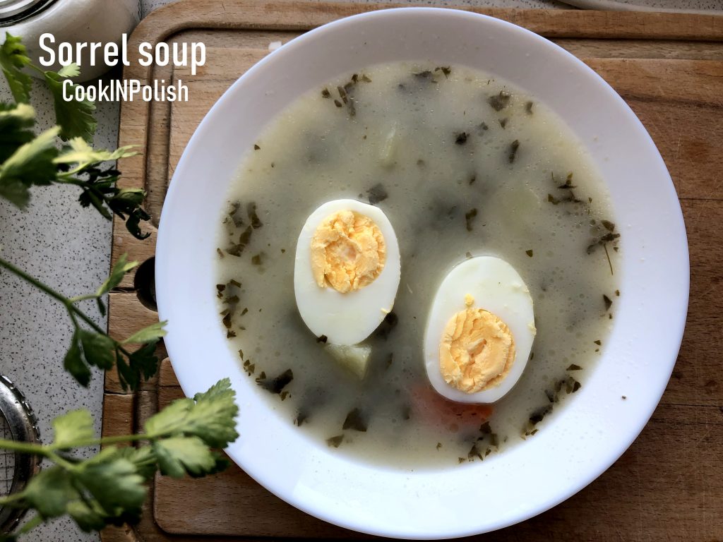 Polish sorrel soup served in a plate with hard boiled egg.