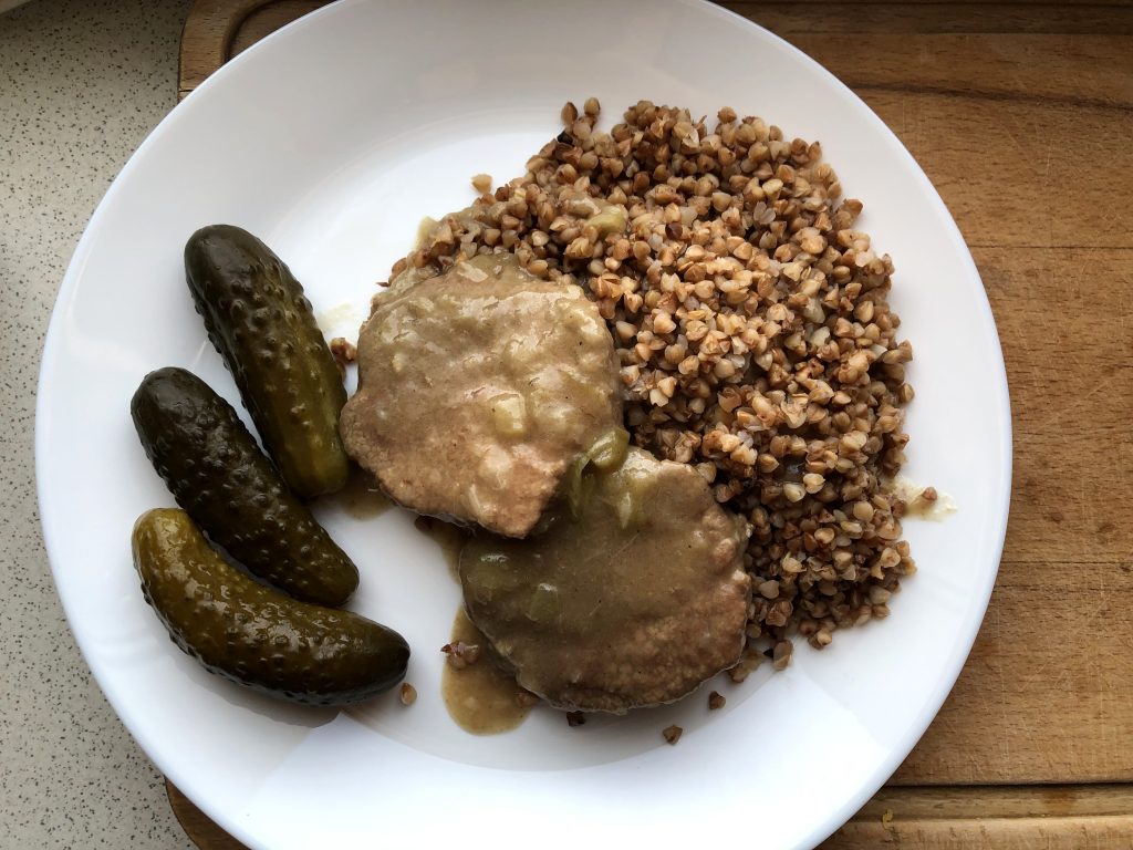 Beef cutlets with buckwheat and pickled cucumber served on the plate