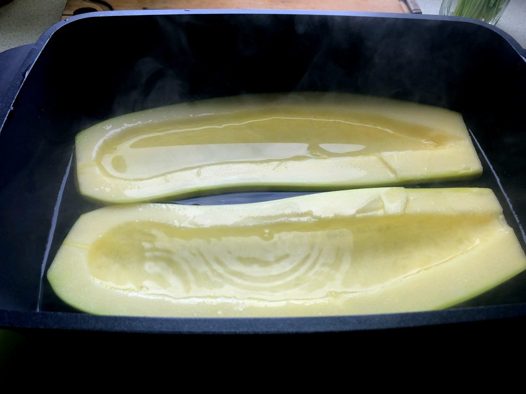 Green large zucchini peeled and covered in hot water