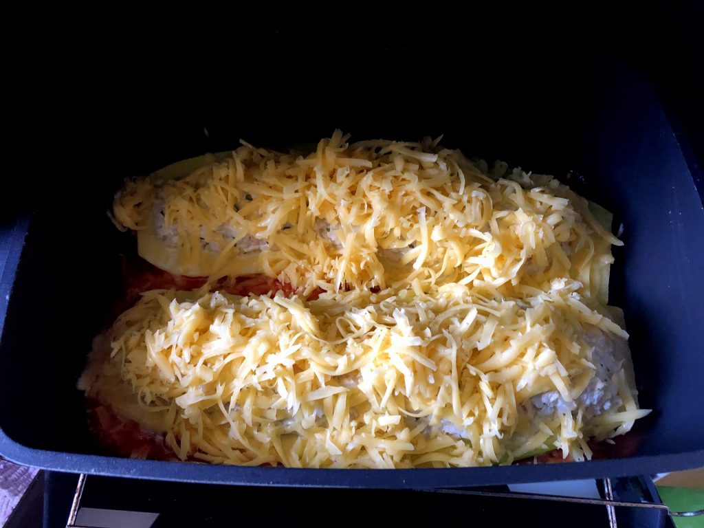 Zucchini ready to be baked: stuffed with raw meat filling.and cheese