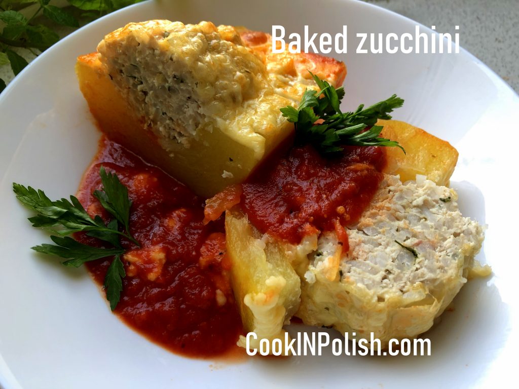 Ready baked Polish stuffed zucchini on the plate with tomato sauce.