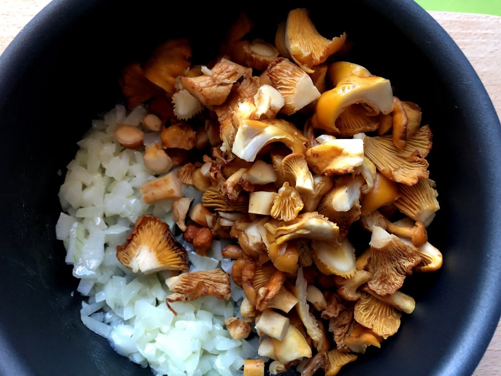 Chanterelles frying on the pan with onions.