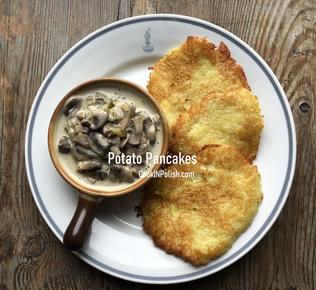 Potato pancakes served on a plate with mushroom sauce