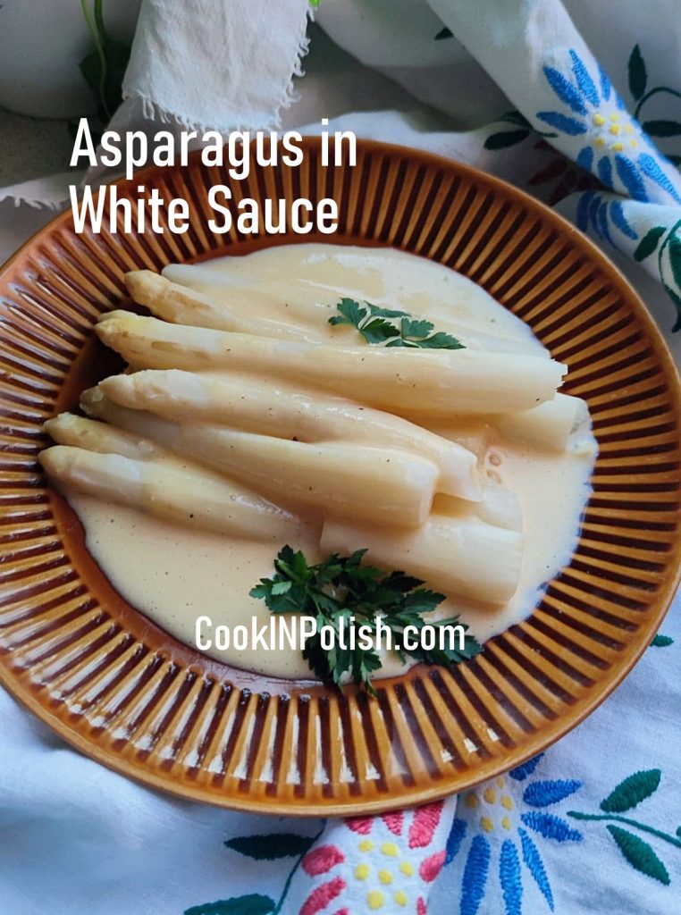 asparagus in white sauce served on the plate