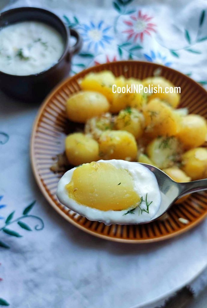 Zsiadłe Mleko and Potatoes served on a table. Scooping potatoes and filling the spoon up with zsiadłe mleko