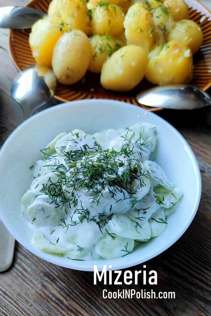 Mizeria Polish cucumber salad served on a plate to accompany new potatoes with dill and butter