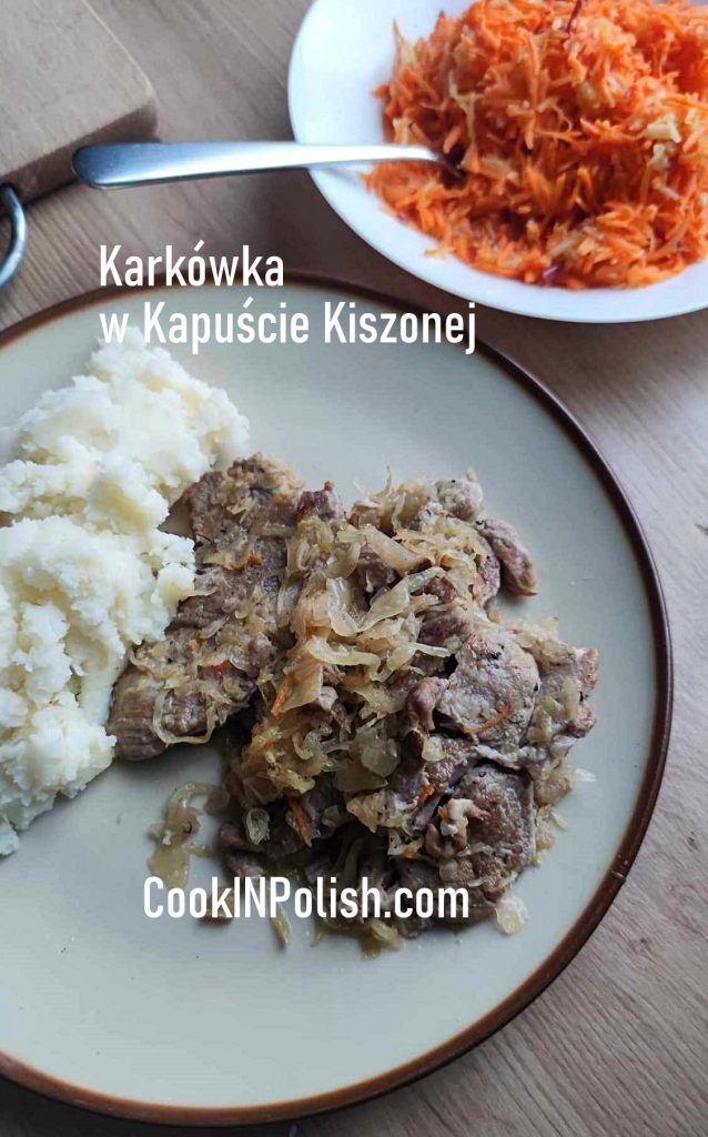 Pork Neck in Sauerkraut served on a plate with potatoes and carrot salad